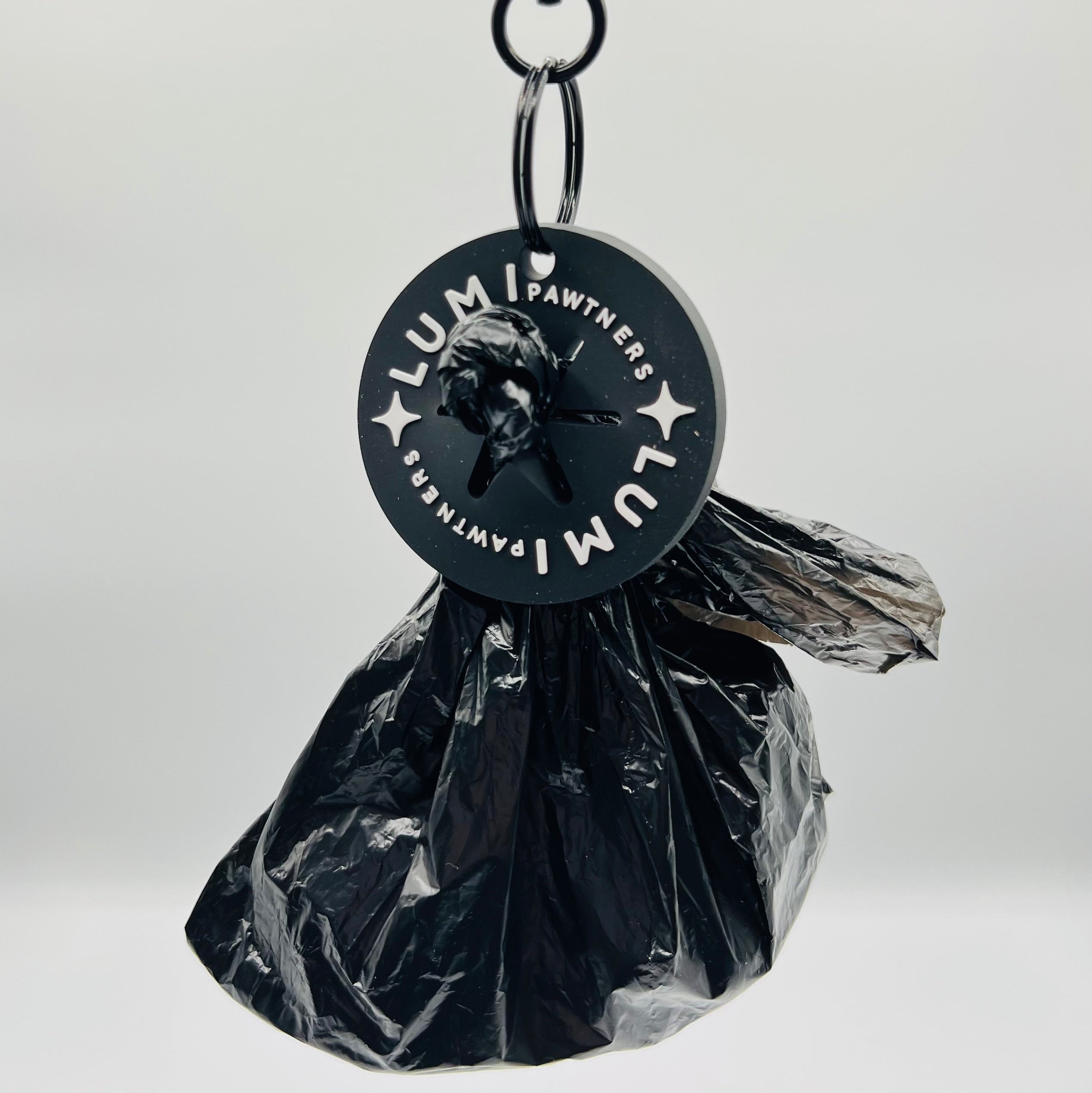 Black plastic bag with a Lumi Poop Loop on a white background